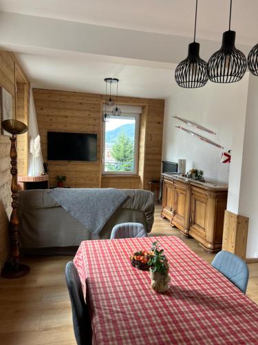 ein Wohnzimmer mit einem Tisch und einem Sofa in der Unterkunft L'apparté de G, Gîte 3 étoiles de montagne cosy in Gérardmer