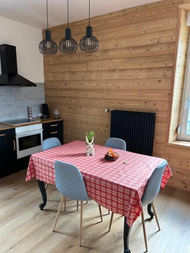 einen Esstisch mit einem roten karierten Tischtuch in der Unterkunft L'apparté de G, Gîte 3 étoiles de montagne cosy in Gérardmer