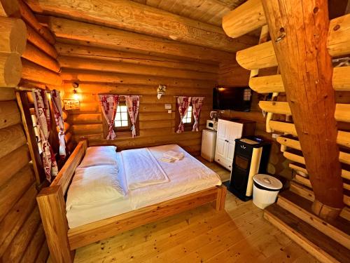 1 dormitorio con 1 cama en una cabaña de madera en Ubytovanie Koliba Pacho - Zrub Zuzka en Prievidza