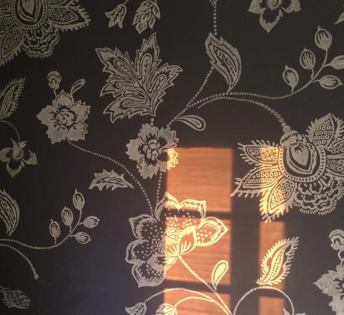 a bedroom with a black and white floral wallpaper at La Rocca Guest House & Spa in Montefalco