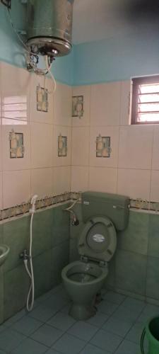 baño con aseo verde y ventana en Jayam home stay, en Yercaud