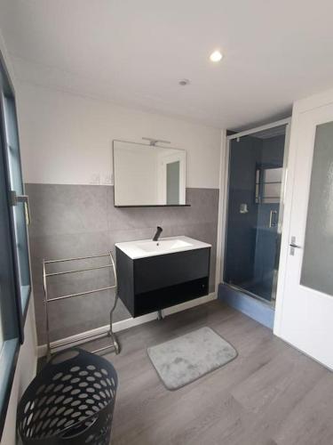 une salle de bain avec un lavabo, un miroir et une chaise dans l'établissement villa la chamat 16 personnes, à La Tremblade