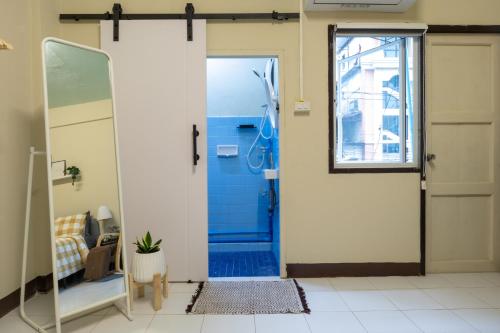 ein Bad mit einer Dusche und einer blauen Tür in der Unterkunft 204hideaway-Local Room with Street Food only 15 min walk to Skytrain in Bangkok