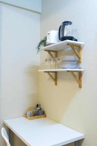 a kitchen shelf with plates and utensils on it at 204hideaway-Local Room with Street Food only 15 min walk to Skytrain in Bangkok