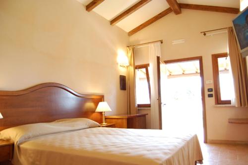 sypialnia z łóżkiem w pokoju z drzwiami w obiekcie Hotel Tenuta dell'Argento Resort w mieście Civitavecchia
