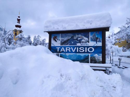 a pile of snow in front of a sign at Casa vacanze Rododendro in Tarvisio
