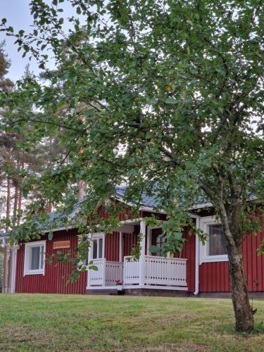 uma casa vermelha e branca com uma árvore em frente em Lomatalo Honkamäki 