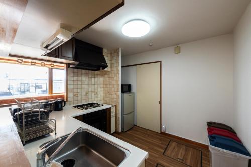 a kitchen with a sink and a stove at The COMFORIA in Sapporo