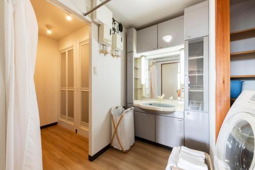 a bathroom with a sink and a washing machine at The COMFORIA in Sapporo