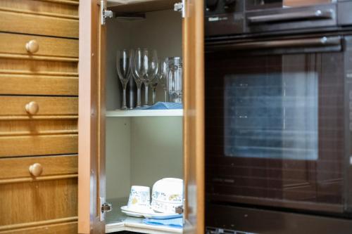 a cabinet with utensils in it next to a microwave at The COMFORIA in Sapporo