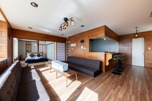 a living room with a couch and a flat screen tv at The COMFORIA in Sapporo
