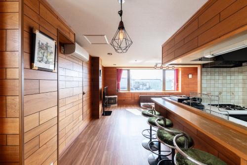 a kitchen with a long counter with stools at The COMFORIA in Sapporo