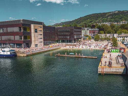 a group of people standing on a dock in a body of water at Byleilighet i sjøkanten m terrasse in Bergen