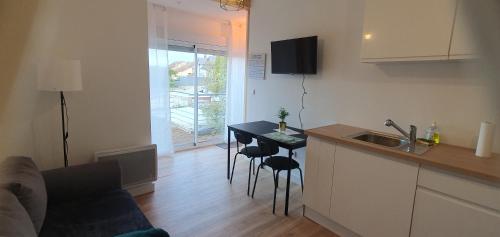 eine Küche mit einem Tisch und Stühlen im Zimmer in der Unterkunft Charmant T2 avec grande terrasse quartier Jardin Massey in Tarbes