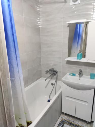 a bathroom with a tub shower and a sink at Квартира для приятного отдыха! Удобства и комфорт! in Tiraspol