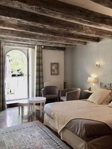 une chambre avec un lit, une table et une fenêtre dans l'établissement Chambres D'hôtes Du Domaine De Jacquelin, à Saint-Germain-du-Puy