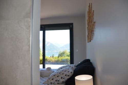 a living room with a couch and a large window at Le Panorama du Lac in Sévrier