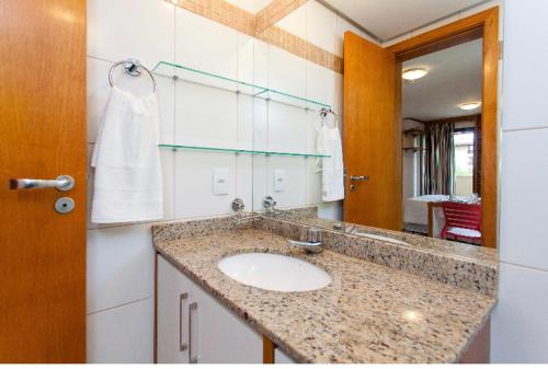 a bathroom with a sink and a mirror at Flat na Beira do Lago 5min da Esplanada dos Ministérios in Brasília