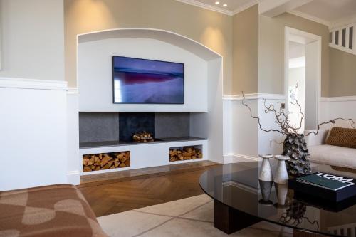 a living room with a fireplace with a tv above it at Oakvale Villa Sand in Åhus