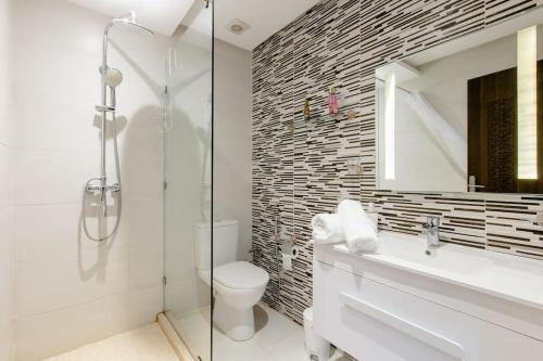 uma casa de banho com um chuveiro, um WC e um lavatório. em Appartement résidence Marrakech haut standing piscine em Marrakech