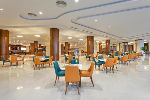 a restaurant with tables and chairs in a building at Xanadu Makadi Bay - High Class All Inclusive in Hurghada