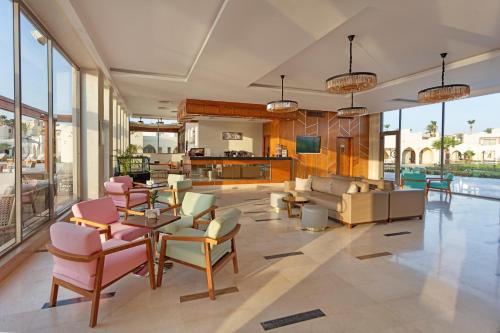 a living room with pink chairs and a couch at Xanadu Makadi Bay - High Class All Inclusive in Hurghada