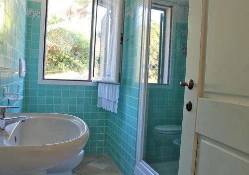 y baño con bañera, lavabo y aseo. en Terre d'Arcipelago Appartamenti, en Cavo