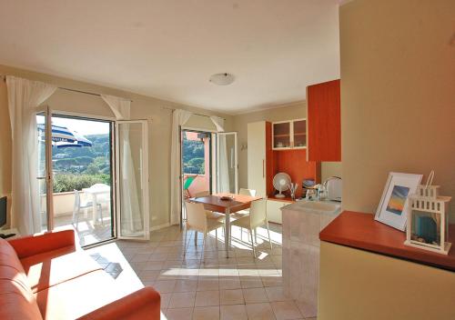 cocina y sala de estar con mesa y sillas en Terre d'Arcipelago Appartamenti, en Cavo