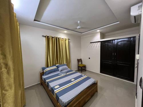 a bedroom with a bed with blue and white sheets at MonGite in Cotonou