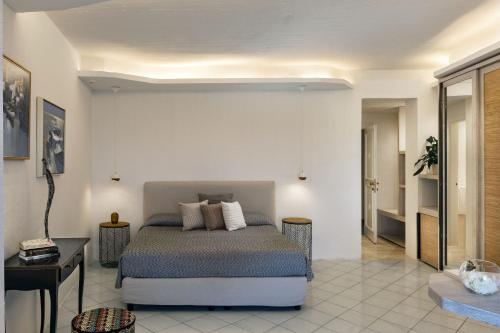 a bedroom with a bed and a desk in a room at Club Hotel Baja Sardinia in Baja Sardinia