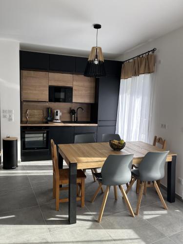 une cuisine et une salle à manger avec une table et des chaises en bois dans l'établissement Paradis vue Lac et Montagnes, à Annecy