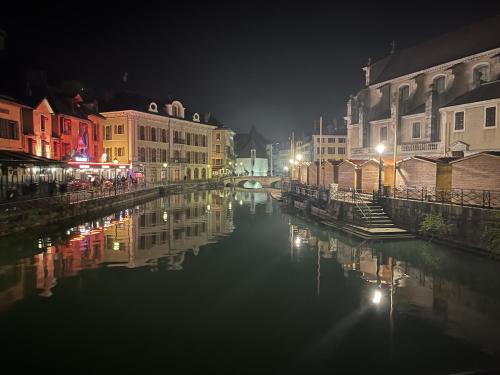 - une vue sur un canal la nuit avec des bâtiments dans l'établissement Paradis vue Lac et Montagnes, à Annecy