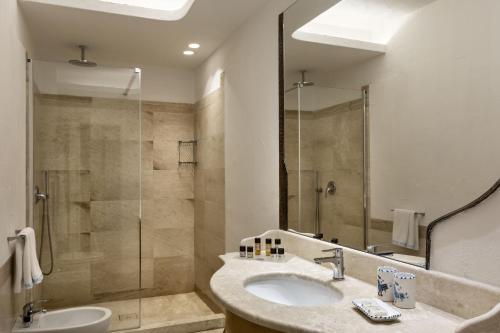 a bathroom with a sink and a shower at Club Hotel Baja Sardinia in Baja Sardinia