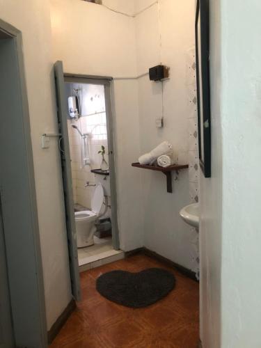 a small bathroom with a toilet and a sink at The apartment house in Mbale