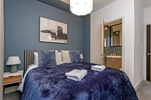 um quarto com uma cama grande e paredes azuis em PRIME City Centre Location, THE JUKE BOX SUITE, Secure Gated FREE Parking Space, Unique STYLISH Apartment, Two Bathrooms em Milton Keynes