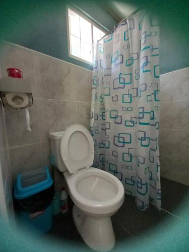 a bathroom with a toilet and a shower curtain at Bohol-Simple and Elegant Suite in Tagbilaran City