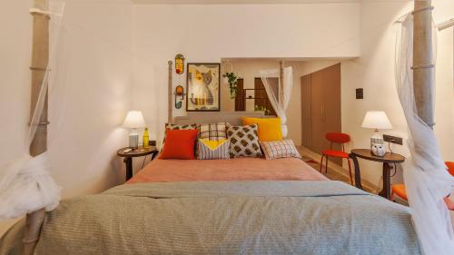 Un dormitorio con una cama grande con almohadas de colores. en Villa Belle Vue- 4BHK Private Pool & Party Hall By StayMonkey, en Lonavala