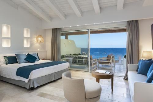 a bedroom with a bed and a view of the ocean at Club Hotel Baja Sardinia in Baja Sardinia