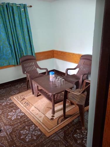 Habitación con mesa y 2 sillas en Jayam home stay, en Yercaud