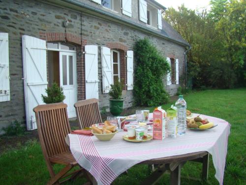 una mesa de picnic con comida en un patio en Entre Mont St Michel et Merveille, en Vains