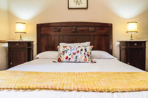 a bed with a wooden headboard and a pillow on it at Pozuelo 3 JABUGO in Jabugo