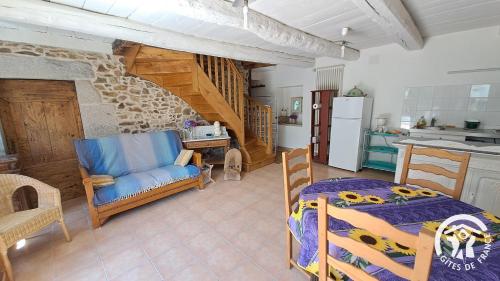 eine Küche und ein Wohnzimmer mit einem Bett und einem Tisch in der Unterkunft Guyor in Le Bez