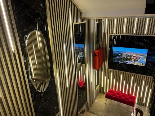una habitación con un banco rojo y un televisor. en The Independent Hotel Taksim, en Estambul