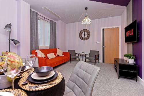 a living room with a couch and a table at PRIME City Centre Location, THE JUKE BOX SUITE, Secure Gated FREE Parking Space, Unique STYLISH Apartment, AIR CONDITIONING & Two Bathrooms in Milton Keynes