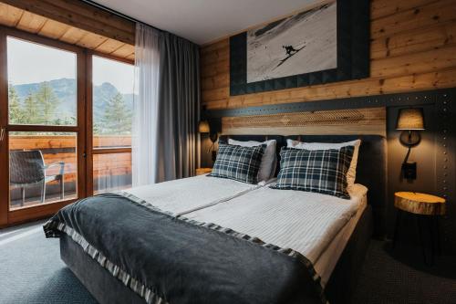 a bedroom with a bed and a large window at New Apartamenty Jan in Zakopane