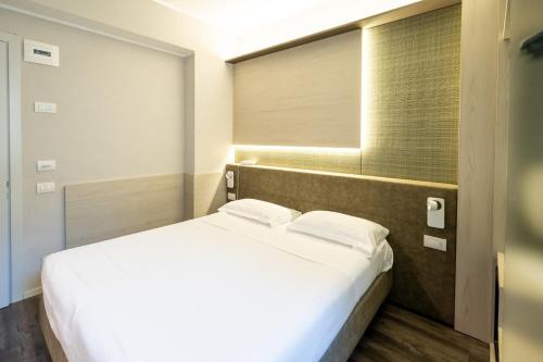 a white bed in a room with a window at Hotel Des Etrangers in Milan