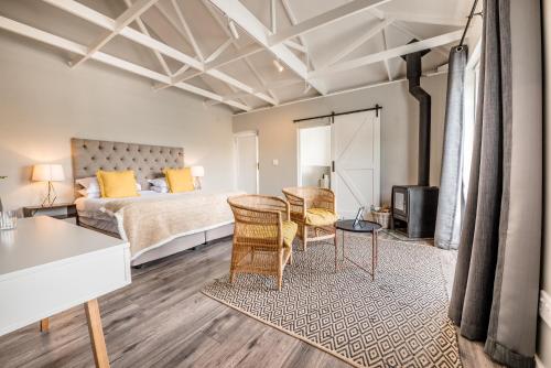 a bedroom with a bed and a table and chairs at Corner House Residence in Franschhoek