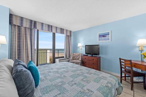 a bedroom with a bed and a television and a balcony at Seaside Serenity Oceanview Suite w Amazing Views 604 in Myrtle Beach