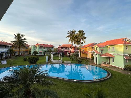 una gran piscina en un patio con casas en Rosewood By The Beach Goa en Benaulim
