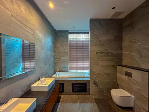 a bathroom with two sinks and a bath tub at Villa Menara Bang Tao in Phuket Town